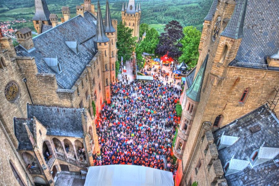 Blick von oben auf Besucherströme zwischen Burgmauern