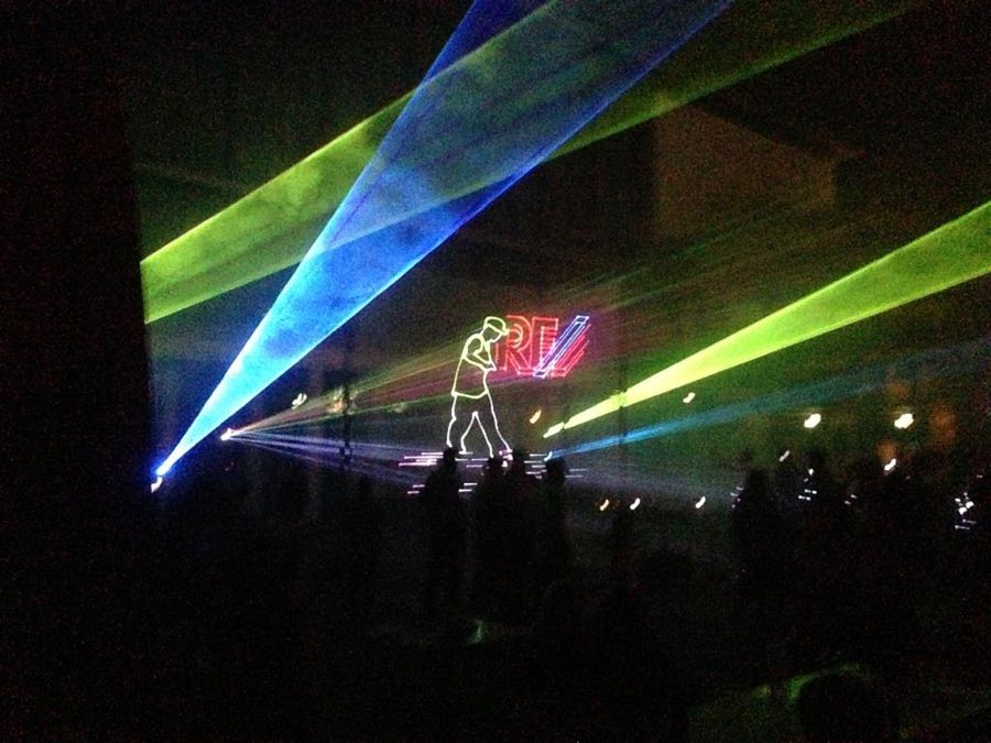 Lasershow mit grünen und blauen Strahlen über einer Bühne